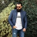 Navy Blue Quilted Jacket: "Men's navy blue quilted jacket styled with casual ripped jeans."